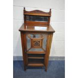 AN EDWARDIAN WALNUT MUSIC CABINET, with a mirrored raised back with a shelf, a single door with four