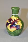 A SMALL MOORCROFT POTTERY BOTTLE VASE, decorated with tubelined pink/purple and yellow Hibiscus