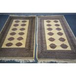 A PAIR OF 20TH CENTURY TEKKE WOOLLEN RUGS, twelve medallions within a beige field, and multi strap