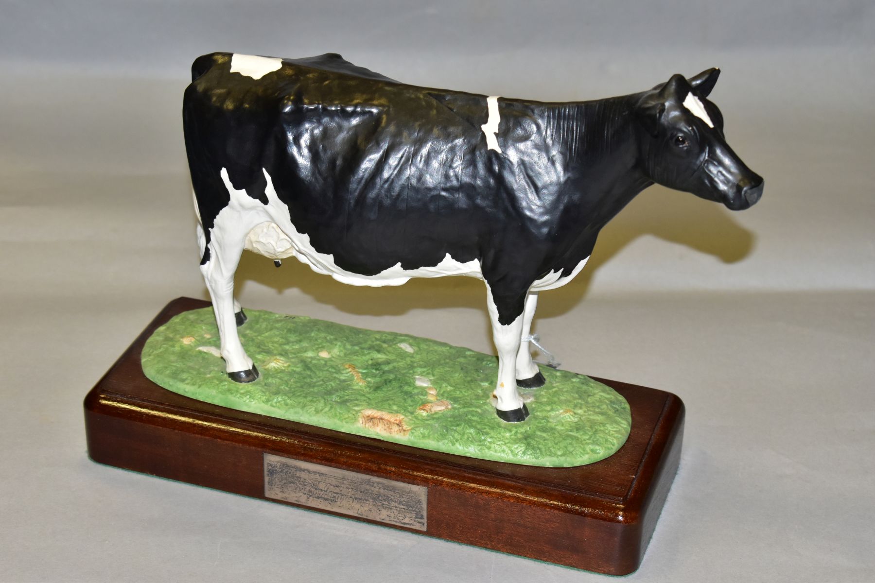 A SHEBEG ISLE OF MAN POTTERY FRESIAN COW, modelled by John Harpur, numbered 112, mounted to a wooden