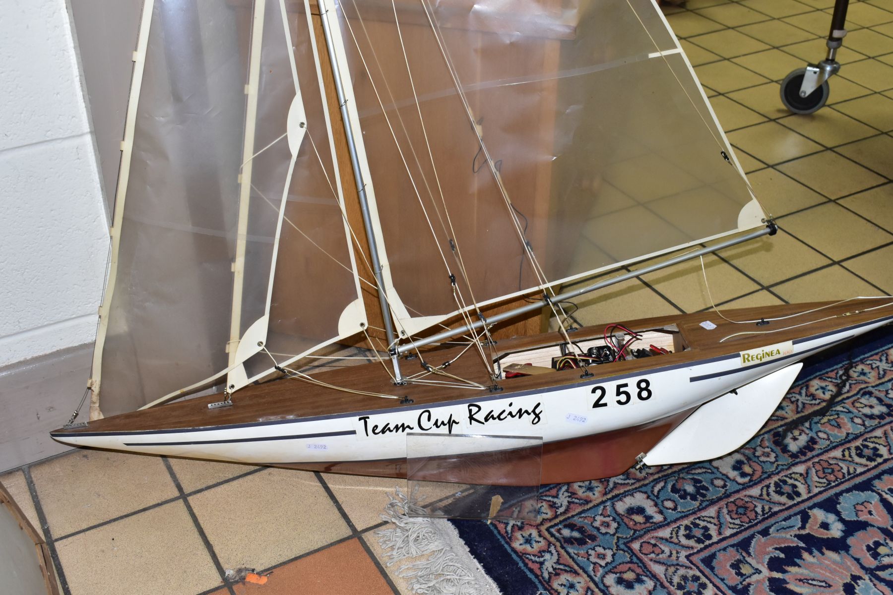 A SCRATCH BUILT MODEL YACHT, at full sail, the deck with rigging and clear sails, motor in hull,