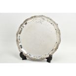 A SILVER SALVER, circular wavy form, gadrooned rim, raised on four scroll feet, hallmarked 'J B