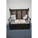AN EARLY 20TH CENTURY OAK HALL SETTLE, with bergère back, barley twist supports, open armrests and