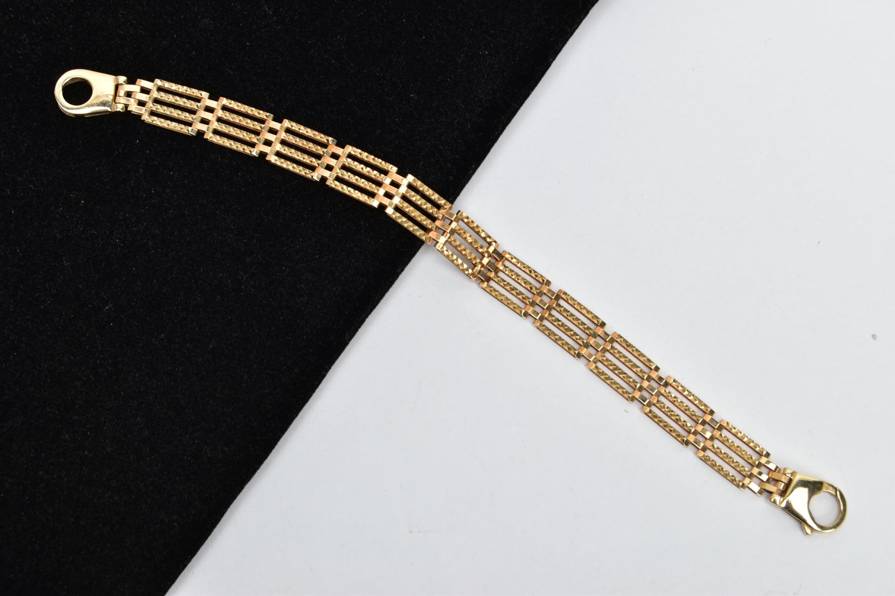 A 9CT GOLD GATE BRACELET, four bar gate bracelet diamond cut pattern to the one side the other a