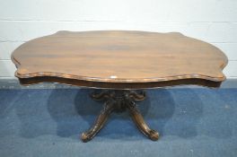 A LATE VICTORIAN WALNUT TILT TOP LOO TABLE, with a wavy edge, with a rosewood border, on a single