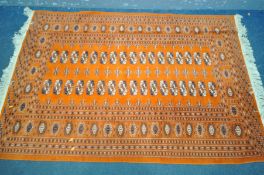 A 20TH CENTURY TEKKE WOOLLEN RUG, thirty four medallions withing an orange field, and a multi