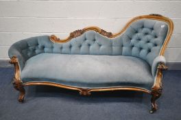 A VICTORIAN WALNUT CHAISE LONGUE, with pale blue upholstered button back, within a foliate and