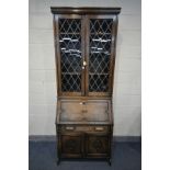 AN EARLY 20TH CENTURY OAK BUREAU BOOKCASE, with double lead glazed doors, enclosing three adjustable