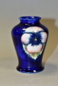 A MOORCROFT POTTERY SMALL BALUSTER VASE DECORATED WITH A PANSY DESIGN ON A BLUE GROUND, impressed