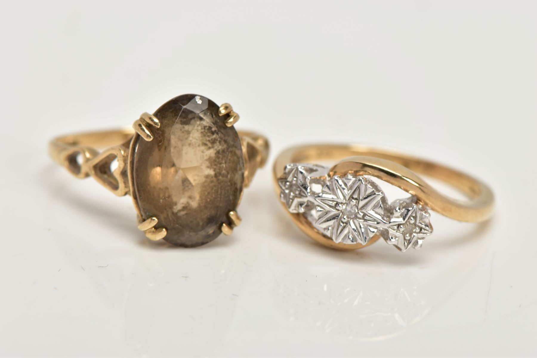 TWO 9CT GOLD RINGS, an oval cut stone assessed as Smokey quartz, prong set in a yellow gold, leading