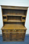 A REPRODUCTION OAK DRESSER, plate rack with two shelves, two pigeon holes and two drawers, base with