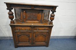 A REPRODUCTION OAK COURT CUPBOARD, canopy top with a single carved cupboard door, with acorn