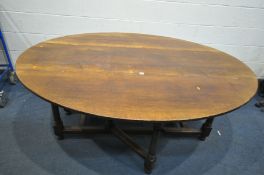 A REPRODUCTION OAK OVAL WAKE TABLE, on turned and blocked legs, united by stretchers, length 183cm x