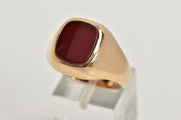 A 9CT GOLD HEAVY SIGNET RING, a rounded square carnelian inlayed in a substantial yellow gold mount,
