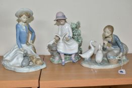 A LLADRO FIGURE AND TWO NAO FIGURES, comprising a Lladro 'Food for Ducks, no.4849, sculpted by