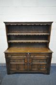 A REPRODUCTION OAK DRESSER, the triple plate rack top with a wavy apron, over a base with two