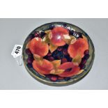 A MOORCROFT POTTERY SHALLOW CIRCULAR BOWL DECORATED IN THE POMEGRANATE PATTERN ON A MOTTLED BLUE