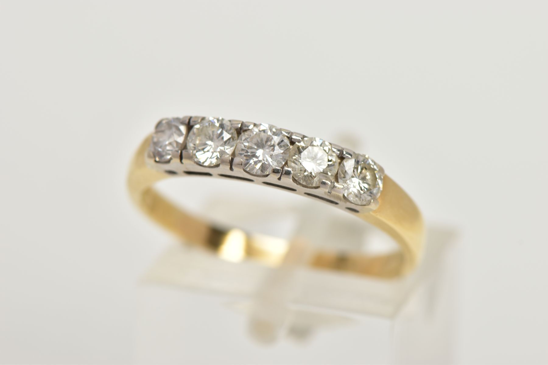 A YELLOW METAL FIVE STONE DIAMOND RING, set with five slightly graduating round brilliant cut