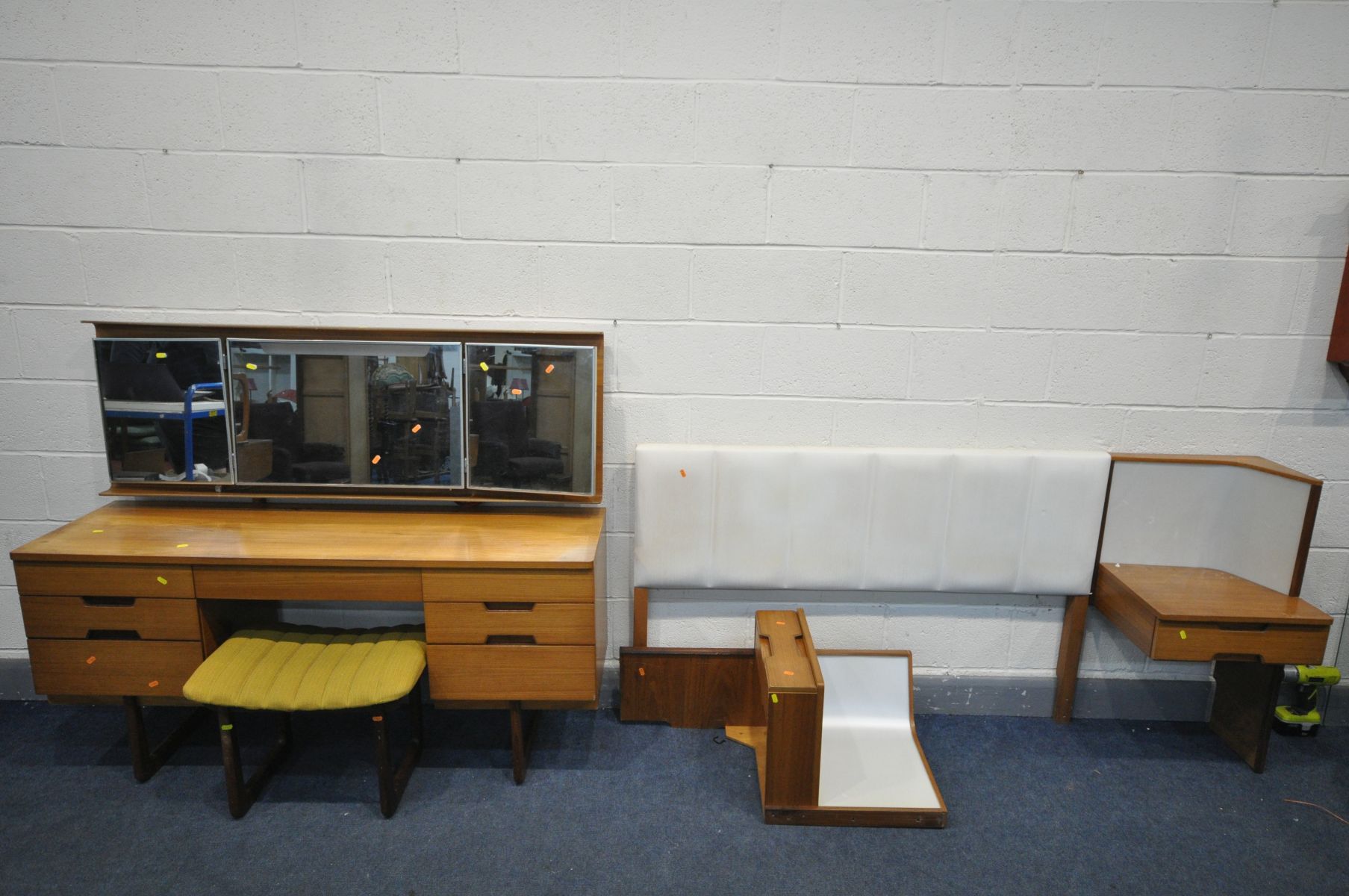 A UNIFLEX FIVE PIECE TEAK DRESSING TABLE, with a plywood back enclosing triple mirrors and seven