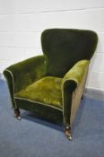 A 19TH CENTURY GREEN UPHOLSTERED ARMCHAIR, on shaped front legs and brass casters