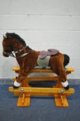 A FABRIC ROCKING HORSE, on a beech trestle stand, length 101cm x height 106cm