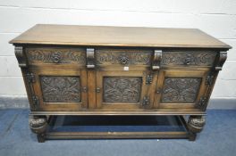 A REPRODUCTION OAK SIDEBOARD, with three drawers over three cupboard doors, both with foliate