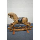 A 20TH CENTURY IAN ARMSTRONG LAMINATED ROCKING HORSE, on a trestle base, bearing brass label width