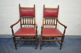 A PAIR OF ARTS AND CRAFTS STYLE OAK ARMCHAIRS, with open armrests, and red leatherette upholstery (