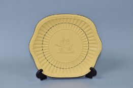A 20TH CENTURY WEDGWOOD CANEWARE BREAD AND BUTTER PLATE, moulded grains of corn rim, faun and