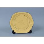 A 20TH CENTURY WEDGWOOD CANEWARE BREAD AND BUTTER PLATE, moulded grains of corn rim, faun and