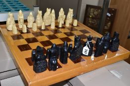 AN ISLE OF LEWIS STYLE CHESS SET, with wooden board 49.5cm square, cast resin cream and black pieces