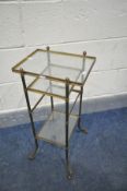 A 20TH CENTURY FRENCH BRASS THREE TIER STAND, with glass inserts, on out splayed legs and casters,