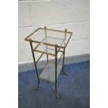 A 20TH CENTURY FRENCH BRASS THREE TIER STAND, with glass inserts, on out splayed legs and casters,