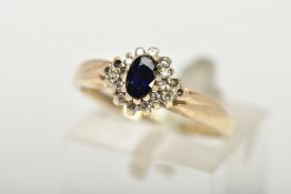A 9CT GOLD CLUSTER RING, a blue oval stone believed to be sapphire, set with a surround of round