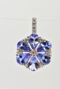 A YELLOW METAL TANZANITE AND SPINEL FLOWER PENDANT, set with six pear cut tanzanite's with