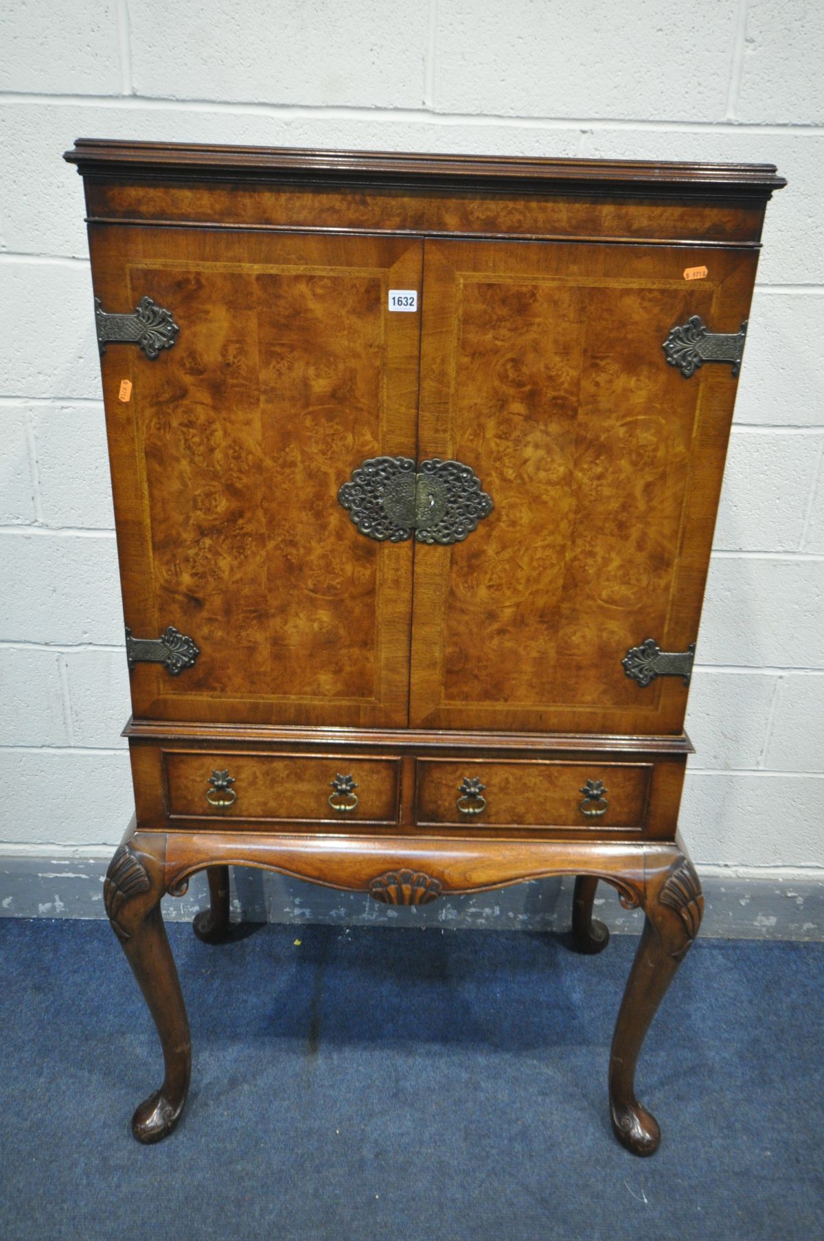 A REPRODUCTION QUEEN ANNE STYLE WALNUT TWO DOOR COCKTAIL CABINET, enclosing two shelves, mirrored