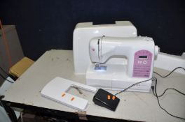 A SINGER STARLET MODERN SEWING MACHINE with outer cover, table extension, peddle and power cable (