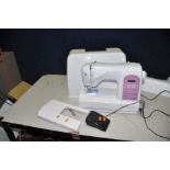 A SINGER STARLET MODERN SEWING MACHINE with outer cover, table extension, peddle and power cable (