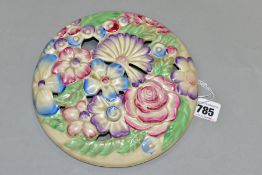 A CLARICE CLIFF WILKINSON LTD CIRCULAR BOUQUET WALL PLAQUE, relief moulded with pastel colour