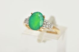 A 9CT GOLD GEM SET RING, designed with a four claw set oval cut green stone, flanked with stepped