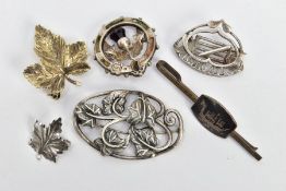 FIVE BROOCHES AND A TIE CLIP, to include a silver oval brooch detailed with an openwork vine design,