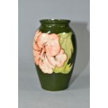 A MOORCROFT POTTERY BALUSTER VASE DECORATED WITH CORAL HIBISCUS ON A GREEN GROUND, impressed