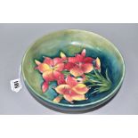 A MOORCROFT POTTERY CIRCULAR FOOTED BOWL DECORATED WITH FREESIA ON A MOTTLED GREEN BLUE GROUND,