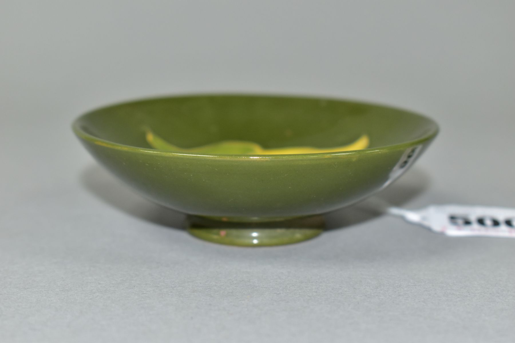 A MOORCROFT POTTERY CIRCULAR PIN DISH DECORATED WITH CORAL HIBISCUS ON A GREEN GROUND, faint - Image 2 of 4