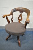 A 19TH CENTURY WALNUT SWIVEL DESK CHAIR, with open armrests, four legs on brass casters (