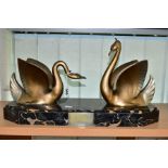 AN ART DECO STYLE SCULPTURE OF TWO GILT METAL SWANS ON A SHAPED RECTANGULAR MARBLE PLINTH, after