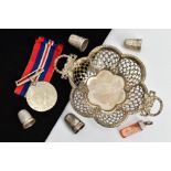 A SILVER BONBON DISH, THIMBLES AND A MEDAL, the dish of a flower shape, pierced rim with bow and