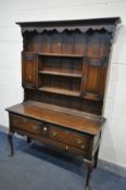 A REPRODUCTION OAK DRESSER, with two fielded panel cupboard doors, flanking three shelves, over