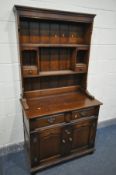 A REPRODUCTION OAK DRESSER, top with two shelves, two pigeon holes and two drawers, the base with