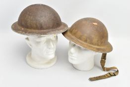 TWO BRITISH WORLD WAR TWO ERA HELMETS, one has the inner lining and chin strap, the other has